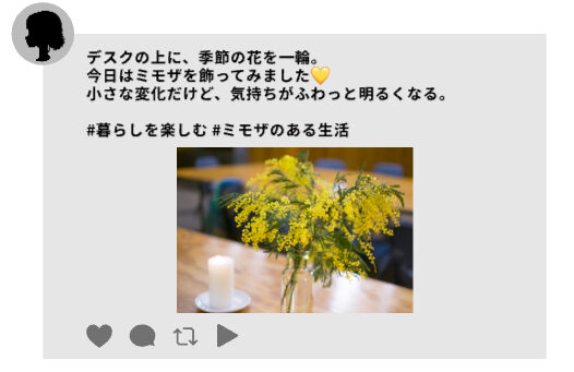 スレッズの投稿例。左上に女性アイコン。「デスクの上に、季節の花を一輪。
今日はミモザを飾ってみました💛
小さな変化だけど、気持ちがふわっと明るくなる。
#暮らしを楽しむ #ミモザのある生活」ミモザがデスクに飾られている写真付き