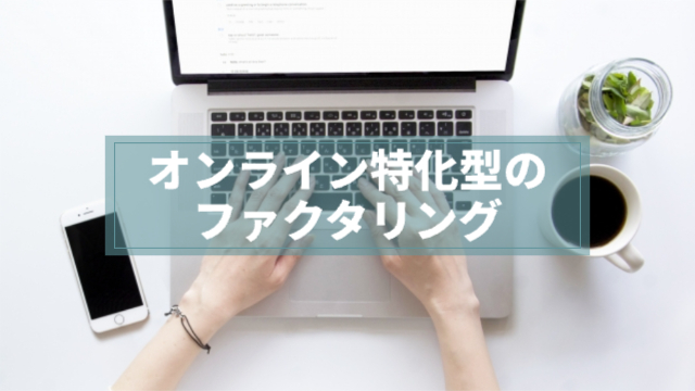 パソコンのキーボードを打っている人の手元が写っている左にスマートフォン、右にコーヒー路観葉植物「オンライン特化型のファクタリング」