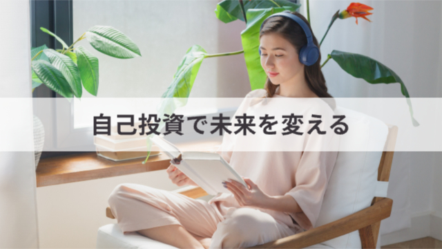 女性がヘッドフォンをしてリラックスチェアに座りながら本を読んでいる様子「自己投資で未来を変える」
