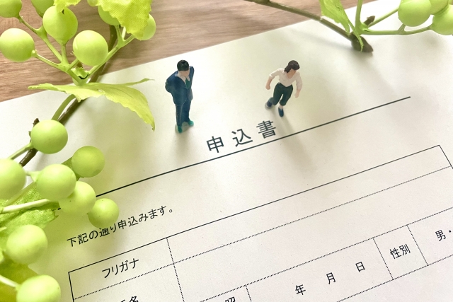 書類の上に2人の人形が立っている