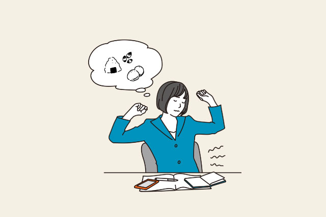 小腹が空いて間食に想いを馳せる仕事中の女性