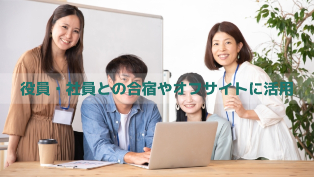 会社員4人がパソコン一台の周りを囲み、こちらを向いて笑顔な様子「役員・社員との合宿やオフサイトに活用」