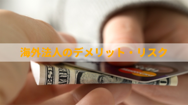 お札とカードを手で持っている様子「海外法人のデメリット・リスク」