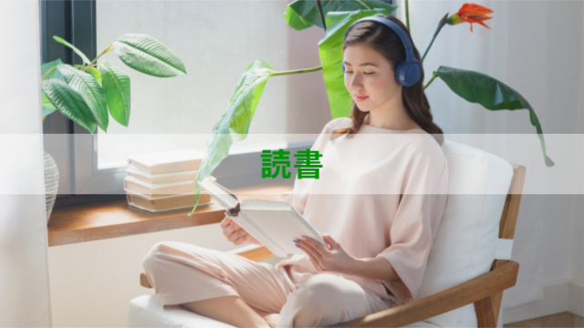 女性が椅子に座ってヘッドフォンをしながら読書している様子「読書」