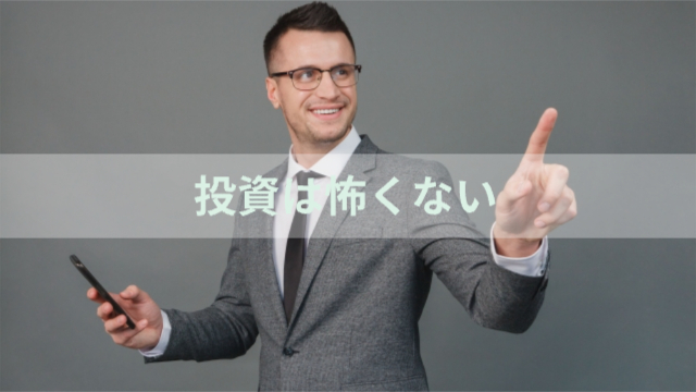 男性がスーツを着て笑顔で指を刺している「投資は怖くない」
